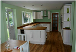 Bespoke Ivory Shaker style kitchen with curved doors and Oak worktops. Instant boiling water tap with inset sink. Integrated appliances including wine cooler and tall oven. Gallery Thumbnail